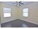 Simple bedroom with dark-grey wood flooring and two windows with blinds at 1516 17Th Nw St, Winter Haven, FL 33881