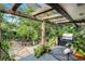 Relaxing back patio with pergola, outdoor kitchen, & tropical landscaping at 1611 Walnut Ave, Winter Park, FL 32789