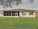 A shot of the home's backyard showing the enclosed patio, lawn, and exterior of the home at 190 Crepe Myrtle Dr, Groveland, FL 34736