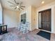 Cozy front porch featuring rocking chairs, ceiling fan, and a patterned brick floor at 190 Crepe Myrtle Dr, Groveland, FL 34736