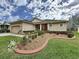 Charming single-story home features a manicured lawn, garden beds, and a welcoming facade at 190 Crepe Myrtle Dr, Groveland, FL 34736