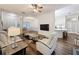 Cozy living room with hardwood floors, a ceiling fan, modern furniture, and an open layout to the kitchen at 190 Crepe Myrtle Dr, Groveland, FL 34736