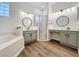 Luxurious main bathroom featuring dual vanities, a separate shower, a soaking tub, and modern fixtures at 190 Crepe Myrtle Dr, Groveland, FL 34736