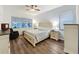 Relaxing main bedroom featuring a ceiling fan, wood floors, lots of natural light, and neutral paint at 190 Crepe Myrtle Dr, Groveland, FL 34736