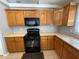 View of kitchen with wood cabinets and black appliances at 1901 Griff Wood Ct, Saint Cloud, FL 34772