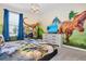 Dinosaur-themed bedroom with mural, TV, and comfortable bed at 1919 Tropical Palms Cir, Kissimmee, FL 34747