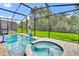 Private screened pool and hot tub with paver deck and grassy backyard at 1919 Tropical Palms Cir, Kissimmee, FL 34747