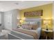 Spacious bedroom with double doors, a queen-size bed, and a yellow accent wall at 2219 Tongass Bnd, Davenport, FL 33896