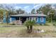 Charming blue house with a white porch and landscaped yard at 23627 Franklin Ave, Sorrento, FL 32776