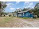 Blue house with a large yard and driveway at 23627 Franklin Ave, Sorrento, FL 32776