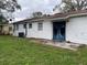 White house back with blue doors and a small patio at 2575 Edmond Cir, Auburndale, FL 33823