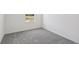 Bright bedroom with grey carpet and a window overlooking the construction site at 3326 Thicket St, Tavares, FL 32778