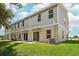 Rear view of a two-story home with gray siding and a grassy yard at 3326 Thicket St, Tavares, FL 32778