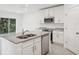 Kitchen island with granite countertop and stainless steel dishwasher at 3328 Thicket St, Tavares, FL 32778