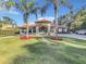 Beautiful home with palm trees, red flowers, and a well-manicured lawn at 3415 S Mellonville Ave, Sanford, FL 32773