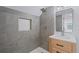 A renovated bathroom with modern grey stone tiles and a wood vanity, complimented by a rainfall shower at 417 Main Trl, Ormond Beach, FL 32174