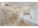 Modern bathroom with a walk-in shower, freestanding tub, and marble tile at 417 Main Trl, Ormond Beach, FL 32174