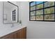 Bathroom featuring a wood vanity with a white countertop and a modern, grid-paned window at 417 Main Trl, Ormond Beach, FL 32174