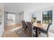 Dining room with a dark wood table, tufted chairs, and natural light from large windows at 417 Main Trl, Ormond Beach, FL 32174