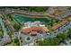 Aerial view of a luxurious pool, clubhouse, waterslides, and residences alongside a lake at 5767 T Bird Ln, Kissimmee, FL 34746