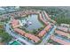 Aerial view of the community showing the pool, lake, clubhouse, condos and parking at 5767 T Bird Ln, Kissimmee, FL 34746