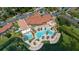 Aerial view showcasing a luxurious pool, clubhouse, and waterslides nestled by a lake at 5767 T Bird Ln, Kissimmee, FL 34746