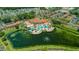 Aerial view featuring a luxurious pool, clubhouse, and surrounding residences near a lake at 5767 T Bird Ln, Kissimmee, FL 34746