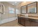 Bright bathroom features double vanity, framed mirrors, soaking tub and tiled shower with glass door at 5767 T Bird Ln, Kissimmee, FL 34746