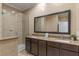 Elegant bathroom featuring double sinks, a large mirror, and a glass-enclosed shower at 5767 T Bird Ln, Kissimmee, FL 34746