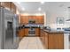 A modern kitchen featuring stainless appliances, dark granite countertops and wooden cabinetry at 5767 T Bird Ln, Kissimmee, FL 34746