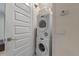 Convenient laundry room with stacked washer and dryer and storage shelving at 5767 T Bird Ln, Kissimmee, FL 34746