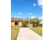 Cute yellow house with red tile roof, landscaped yard, and concrete driveway at 743 Golden Sunshine Cir, Orlando, FL 32807