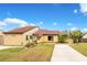 Tan two-story house with red tile accents and a paved driveway at 743 Golden Sunshine Cir, Orlando, FL 32807