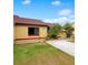 Front view of a yellow house with red tile roof, palm trees, and a landscaped yard at 743 Golden Sunshine Cir, Orlando, FL 32807