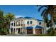 Two-story home with blue roof, two-car garage, and tropical landscaping at 749 S Atlantic S Ave, Ormond Beach, FL 32176