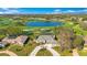 Expansive aerial view of a beautiful home on a lush green golf course near a tranquil lake and blue skies at 8513 Bay Hill Blvd, Orlando, FL 32819
