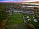 Aerial view of upscale golf course community with clubhouse, pool, and lake at sunset at 8513 Bay Hill Blvd, Orlando, FL 32819