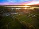 Aerial view of golf course, clubhouse, and lake at sunset at 8513 Bay Hill Blvd, Orlando, FL 32819