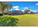 Expansive backyard showcasing a screened-in pool, lush lawn, and mature trees at 8513 Bay Hill Blvd, Orlando, FL 32819