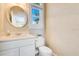 Cozy powder room featuring a modern vanity, toilet, and round mirror above at 8513 Bay Hill Blvd, Orlando, FL 32819