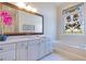 Well-lit bathroom features a large mirror, soaking tub, and decorative stained glass window at 8513 Bay Hill Blvd, Orlando, FL 32819