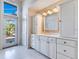 Bright bathroom with white cabinets and view to backyard at 8513 Bay Hill Blvd, Orlando, FL 32819