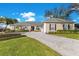 Inviting home exterior showcasing a brick driveway, manicured lawn, and beautifully maintained landscaping at 8513 Bay Hill Blvd, Orlando, FL 32819