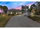 Elegant home exterior featuring a gray brick driveway, manicured landscaping, and tasteful architectural design elements at 8513 Bay Hill Blvd, Orlando, FL 32819