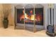 Elegant fireplace with brass screen and fire burning at 8513 Bay Hill Blvd, Orlando, FL 32819