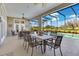 Covered patio with a dining table and comfortable seating area overlooking the sparkling pool and landscape at 8513 Bay Hill Blvd, Orlando, FL 32819