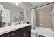 Bathroom with a bathtub and dark brown vanity at 943 Gracie Ridge St, Clermont, FL 34715