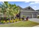 Gray house with three-car garage, palm trees, and manicured landscaping at 943 Gracie Ridge St, Clermont, FL 34715