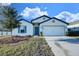 Charming single-story home featuring a well-manicured lawn and a bright blue front door at 1147 Moyle Way, Mascotte, FL 34753