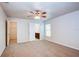 Spacious main bedroom with carpet flooring, a ceiling fan, and ensuite bathroom access at 1147 Moyle Way, Mascotte, FL 34753